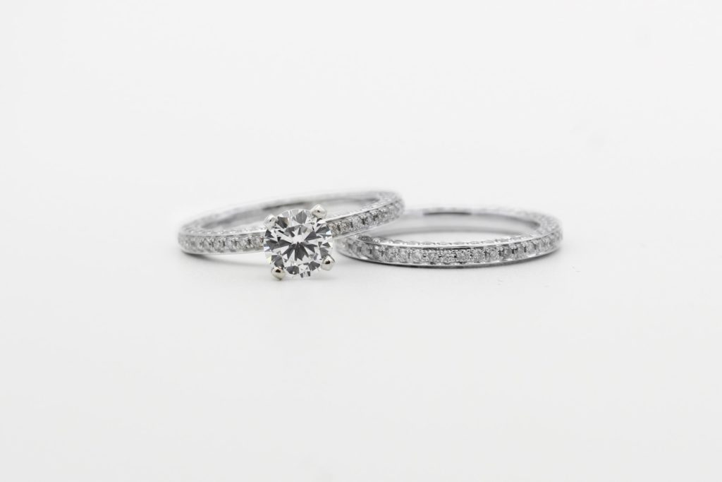 silver diamond studded ring on white surface